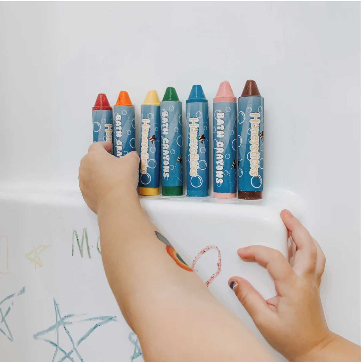 child's hand reaching for crayons on a shelf